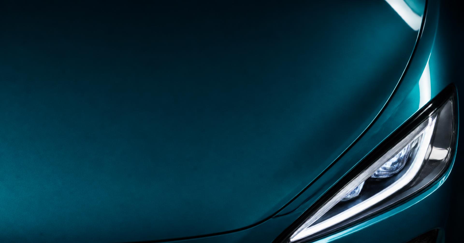 Close-up of a teal car hood and headlight